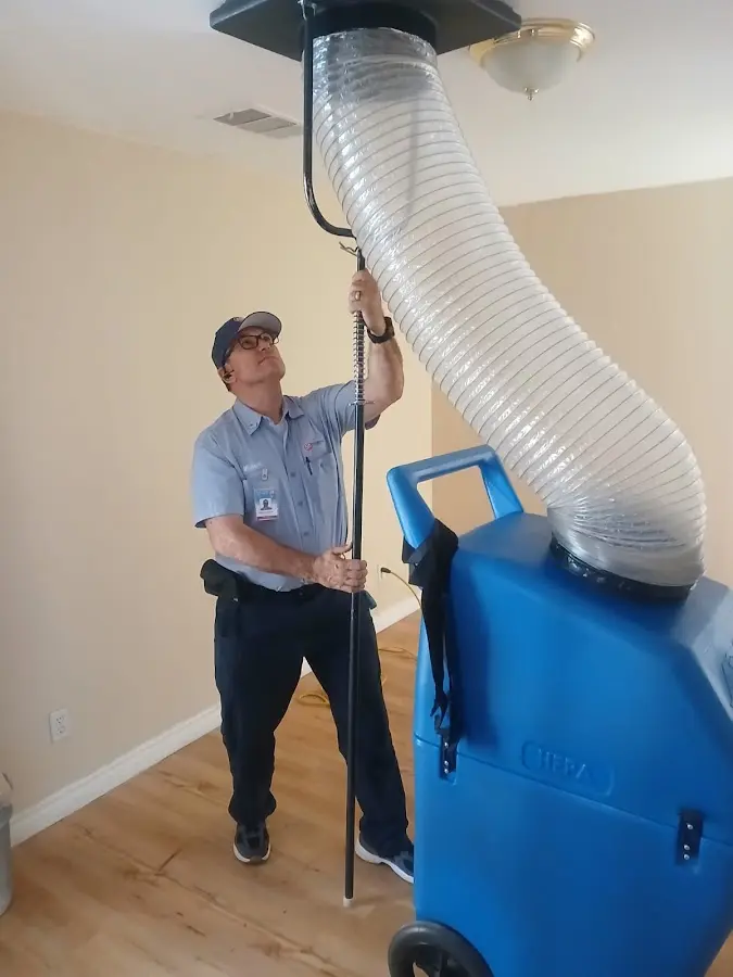 Furnace Tune-Up technician using HEPA equipment in Helotes
