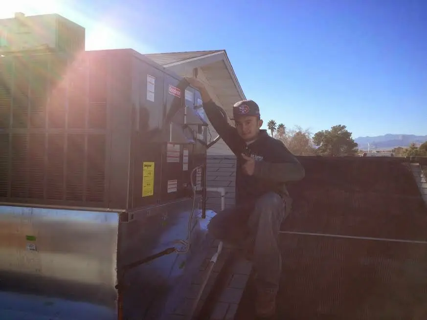 HVAC technician performing Boiler Repair on a rooftop unit in Helotes